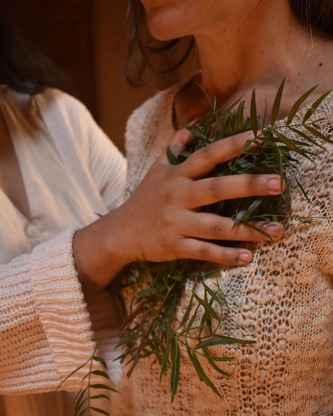 Mano con plantas sobre el corazón de una mujer